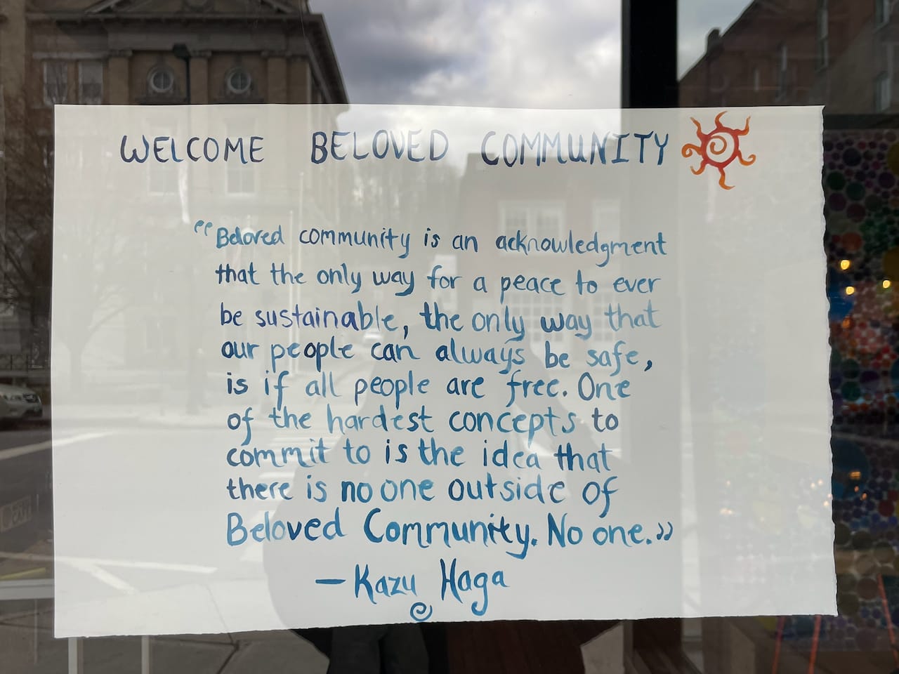 The hand-lettered Kazu Haga quote at the door, under the café’s sun mark.