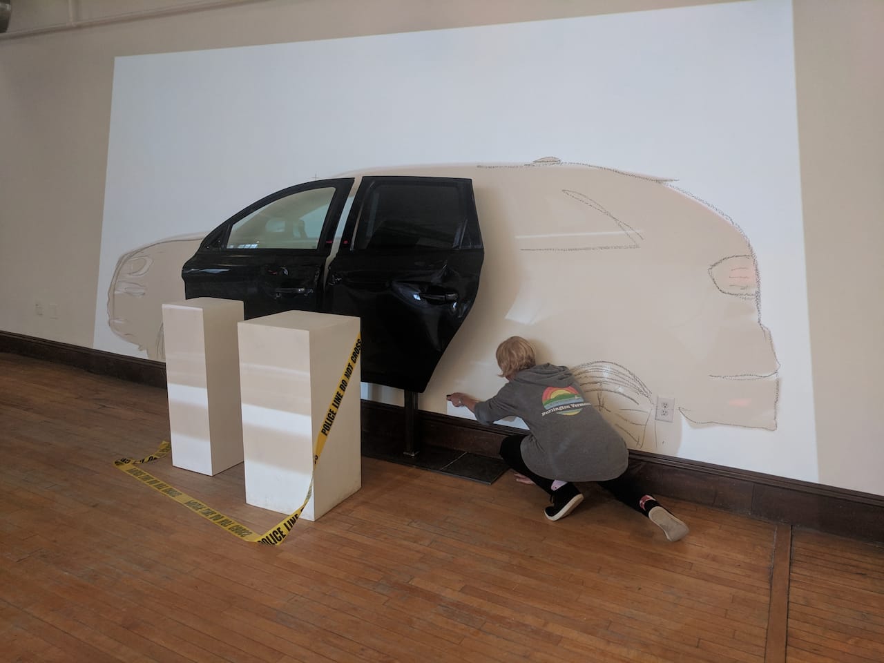 The AUTO-BIOGRAPHY installation, the car drawn onto the gallery wall beside a mounted car door.