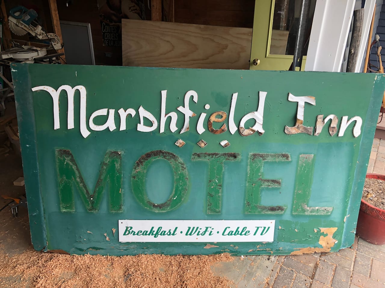 The old sign in the shop, its letters coming off.