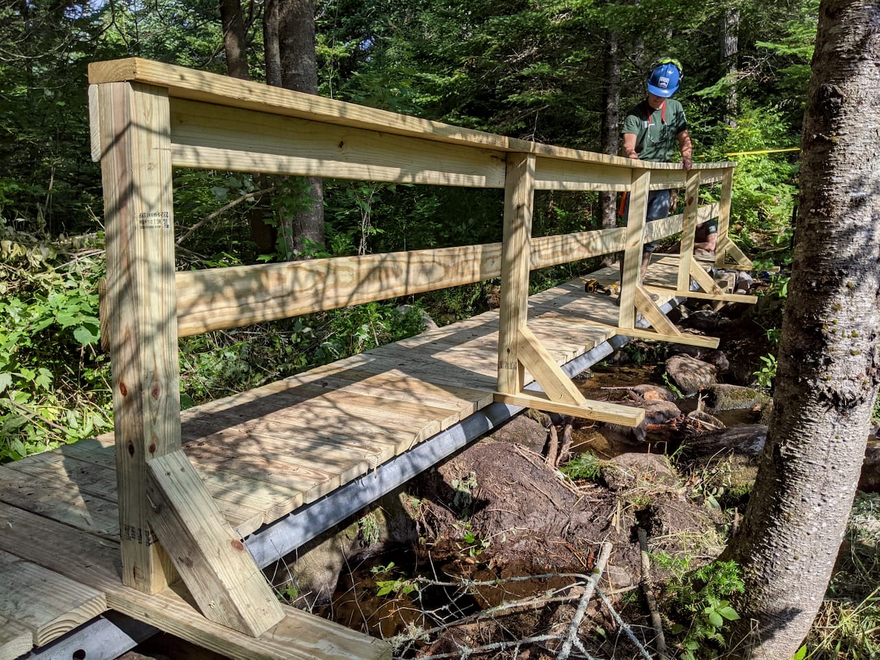 A finished trail bridge over a backcountry brook.